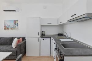 a kitchen with a sink and a couch in a room at Adriatic Heights Holiday Apartments in Kavač