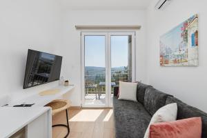 a living room with a couch and a tv at Adriatic Heights Holiday Apartments in Kavač