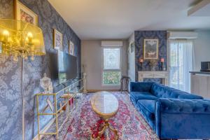 a living room with a blue couch and a table at Chambre d'Amour Jacuzzi Bordeaux Parking in Bruges
