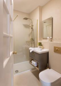 a bathroom with a toilet and a sink and a shower at The Lansdowne Kenmare in Kenmare +65 photos