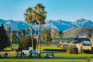 a golf course with palm trees and mountains in the background at Las Dunas 213 - by Welcomely in Oliva