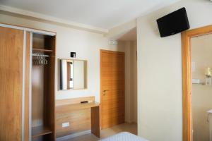 a bedroom with a door and a television on a wall at Hostal Costabella in Fuengirola