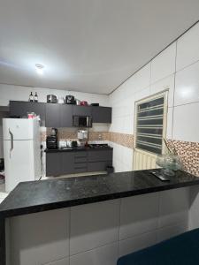 a kitchen with a black counter and a white refrigerator at Casa Timon in Timon