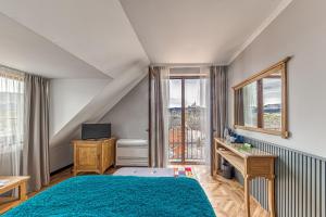 a bedroom with a blue bed and a window at Hotel Studio in Veliko Tŭrnovo