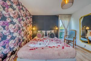 a bedroom with a bed with red rose petals on it at Chambre d'Amour Jacuzzi Bordeaux Parking in Bruges