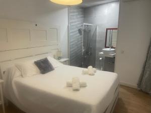 a bedroom with a white bed with towels on it at Catedral Larios Centro in Málaga +209 photos