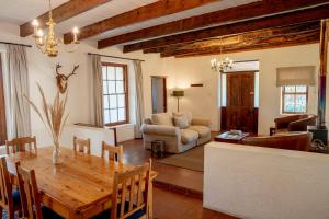 a living room with a table and a couch at Karoo House Collection - Riverdene Lodge in Nieu-Bethesda