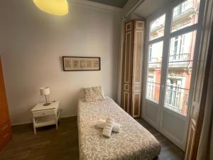 a small bedroom with a bed and a window at Catedral Larios Centro in Málaga