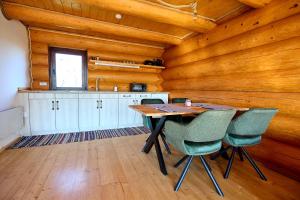 a kitchen with a wooden ceiling and a table and chairs at Golden Log House in Hajdúszoboszló