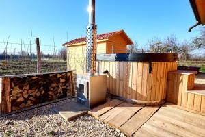 a wooden deck with a stove and a house at Golden Log House in Hajdúszoboszló +2 photos