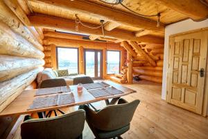 a dining room with a table and chairs in a cabin at Golden Log House in Hajdúszoboszló