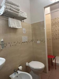 a bathroom with a toilet and a sink and towels at Hotel 26 in Milan