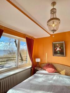 a bedroom with a bed and a window and a chandelier at Exklusive Ferienwohnung Strohberg in Plön