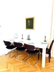 a dining room table with chairs and a white table at Stephansdom apartment in Vienna