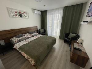 a bedroom with a bed and a desk and a table at Apartmán Rose in Podhájska