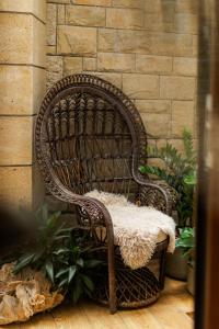 a wicker chair sitting next to a brick wall at Hotel Studio in Veliko Tŭrnovo