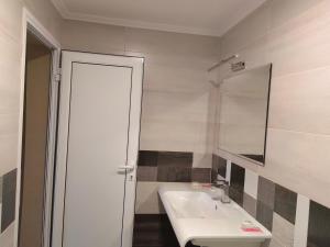 a white bathroom with a sink and a mirror at Пиргуля in General-Toshevo