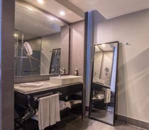 a bathroom with a sink and a mirror at Wyndham Santiago Pettra in Santiago