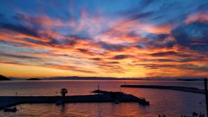 a sunset over a body of water with a pier at Lina`s Apartment & Maisonette in Neo Klima