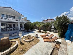 a patio with two chairs and a fire pit in front of a house at Dalyan Grand Garden in Ortaca