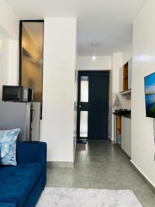 a living room with a blue couch and a door at Haven stay in Kiambu