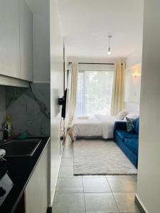 a kitchen and a bedroom with a bed and a blue couch at Haven stay in Kiambu
