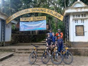 a group of people standing in front of a gate with bikes at Denis cozy homestay in Senaru