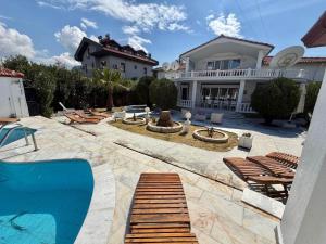 a villa with a swimming pool and a house at Dalyan Grand Garden in Ortaca