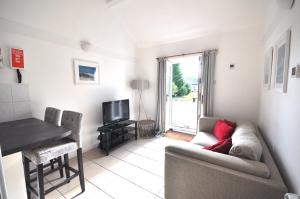 a living room with a couch and a television at Stable Cottage, Whitebridge Farm in Shaftesbury