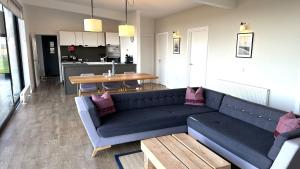 a living room with a blue couch and a table at Jog Lodge 5 By Together Travel - 3 Bed in John O Groats +12 photos