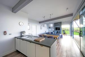 a kitchen with white cabinets and a dining room at Jog Lodge 5 By Together Travel - 3 Bed in John O Groats