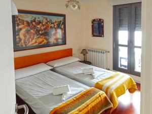 a bedroom with two beds and a painting on the wall at Apartamentos Las Margas Sabiñánigo 3000 in Sabiñánigo