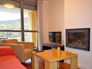 a living room with a couch and a fireplace at Apartamentos Las Margas Sabiñánigo 3000 in Sabiñánigo