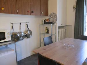 a kitchen with a wooden table and a microwave at La Source - 85 m2 & terrasse privée in Orcival