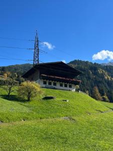 a building on top of a hill with a grass field at Bamerhof in Mittersill