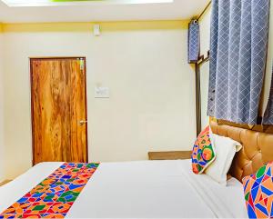 a bedroom with a bed and a wooden door at Hotel Qness in Hyderabad