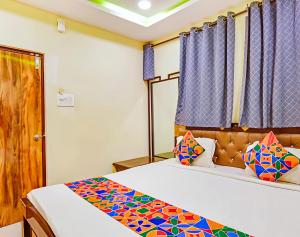 a bedroom with a bed with a colorful comforter at Hotel Qness in Hyderabad