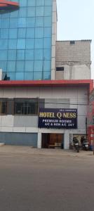 a building with a sign for a hotel at Hotel Qness in Hyderabad