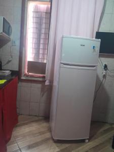a white refrigerator in a kitchen with a window at Hospedagem Mariano in Arraial do Cabo