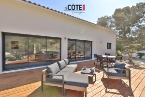 a living room with a couch and chairs on a deck at Villa Concept in Ensuès-la-Redonne