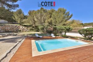 a swimming pool with two lounge chairs next to a wooden deck at Villa Concept in Ensuès-la-Redonne