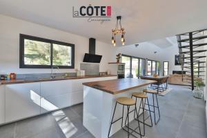 a kitchen with a counter and bar with stools at Villa Concept in Ensuès-la-Redonne +14 photos