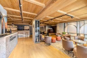 a large room with wooden ceilings and tables and chairs at Hotel Panorama in San Martino di Castrozza