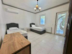 a room with two beds and a table in it at Dalyan Grand Garden in Ortaca +25 photos