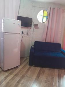 a living room with a couch and a refrigerator at Hospedagem Mariano in Arraial do Cabo