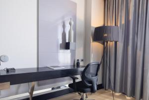 a desk with a chair and a lamp in a room at Wyndham Santiago Pettra in Santiago