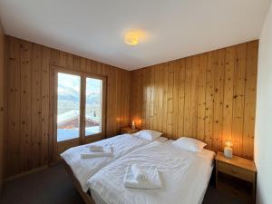 a bedroom with a bed with two towels on it at Fontannets 001 COSY & MOUNTAIN chalet 10 pers in Veysonnaz