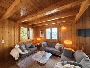 a living room with a couch and a table at Fontannets 001 COSY & MOUNTAIN chalet 10 pers in Veysonnaz