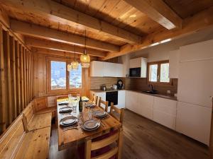a kitchen with a wooden table in a cabin at Fontannets 001 COSY & MOUNTAIN chalet 10 pers in Veysonnaz