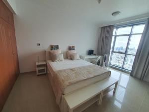 a bedroom with a large bed and a large window at Stylish 2 BR Apartment in Ajman Residences Tower 4 in Ajman 